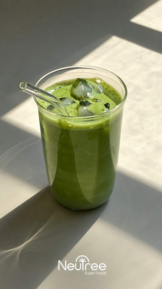 Vaso con bebida verde y hielo al sol